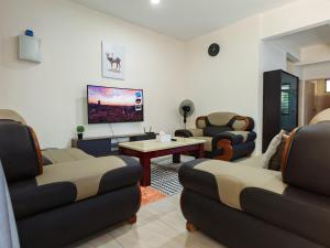 a living room with two couches and a tv at Riverside Landed House 河景湾 in Kota Kinabalu