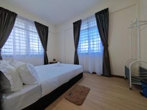 a bedroom with a bed and two large windows at Riverside Landed House 河景湾 in Kota Kinabalu
