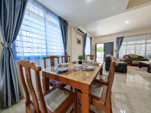 a dining table and chairs in a living room at Riverside Landed House 河景湾 in Kota Kinabalu