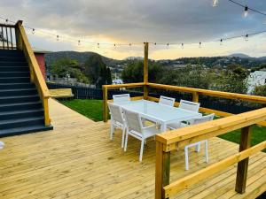 a wooden deck with a white table and chairs on it at Quarry House - Bright and Renovated! in Hobart