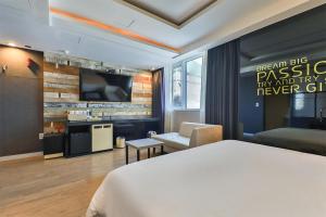 a hotel room with a bed and a flat screen tv at Moonbay Hotel in Busan