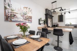a kitchen and dining room with a wooden table and chairs at Swiss Haven - Spacious 3 Bedroom House in Liverpool