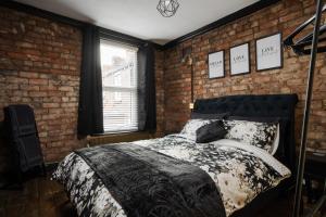 a bedroom with a bed in a brick wall at Swiss Haven - Spacious 3 Bedroom House in Liverpool