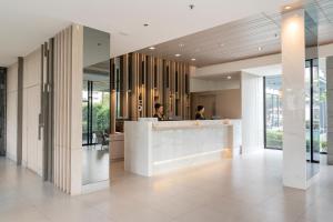 two people sitting at a counter in a lobby at Arden Hotel and Residence by At Mind in Pattaya Central +145 photos