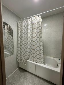 a bathroom with a tub and a shower curtain at Гостиница Kokshe Inn in Kokshetau +16 photos