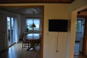 a dining room with a table and a flat screen tv at Chalet-Biel-Bienne in Biel