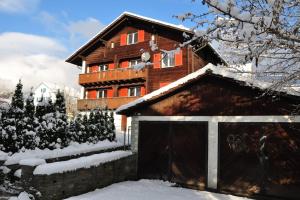 a wooden house with a garage in the snow at Chalet-Biel-Bienne in Biel