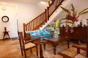a living room with a table and a staircase at Coastal Cloud Backpackers in Unawatuna