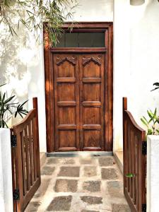 a wooden door on a white building with two fences at Coastal Cloud Backpackers in Unawatuna