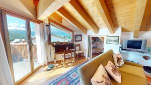 a living room with a couch and a television at Piz Chalchagn in Pontresina
