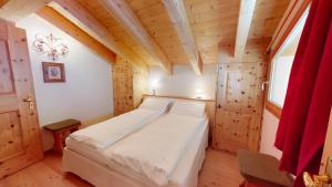 a bedroom with a large bed in a wooden room at Piz Chalchagn in Pontresina