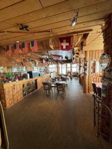 Un comedor con mesas y sillas en un restaurante. en Klausen Ranch, en Urnerboden