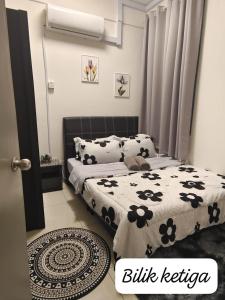 a bedroom with two beds with black and white sheets at Meeymohd Homestay in Ipoh