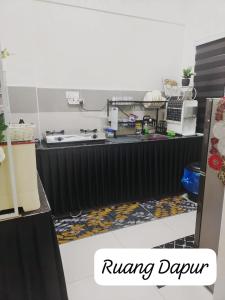 a kitchen with a table with a sink and a counter top at Meeymohd Homestay in Ipoh +3 photos
