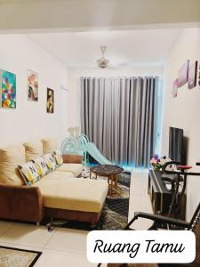a living room with a couch and a tv at Meeymohd Homestay in Ipoh