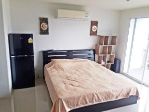 a bedroom with a bed and a black refrigerator at Sunsky Patong beachfront House in Patong Beach