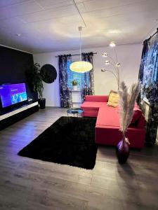 a living room with a red couch and a tv at Villa i Kiruna in Kiruna