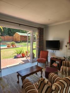 ein Wohnzimmer mit einer großen Glasschiebetür in der Unterkunft Coconut Cottage in Randburg