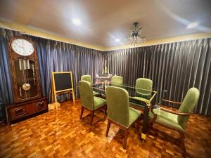 a dining room with a table and chairs and a clock at Newly-renovated Modern Private Thai Villa with Swimming Pool in Ban Khlong Samrong