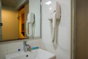 a bathroom with a sink and a phone on the wall at 7Days Premium Nanjing Xinjiekou Subway Station in Nanjing