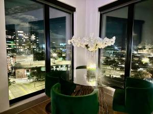 亚特兰大Modern luxury at the Interlock的一间设有玻璃桌和绿色椅子的用餐室