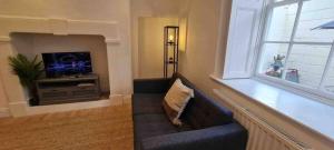 Peaceful apartment with courtyard in town centre في تيتبري: غرفة معيشة مع أريكة وتلفزيون