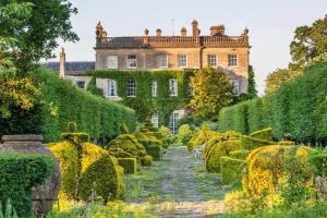 Peaceful apartment with courtyard in town centre في تيتبري: حديقة امام بيت فيه شجيرات