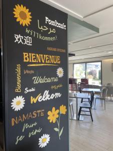 a sign with flowers on a wall in a restaurant at Campanile Saint-Avold in Saint-Avold