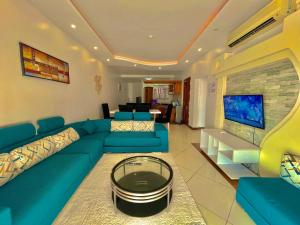 a living room with a blue couch and a tv at Shanzu Two Bedroom Coastal Getaway in Mombasa