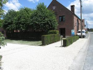 a brick building with a tree next to a street at Hotel Klein Nederlo in Vlezenbeek