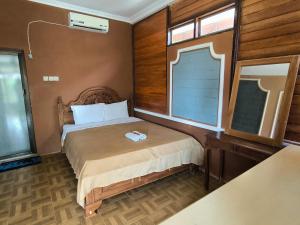 a small bedroom with a bed and a window at Sunrise Sea Hill Cottages in Karimunjawa +57 photos