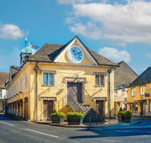 a building with a clock on top of it at Stunning characterful newly refurbished flat in Tetbury