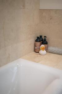 a bath tub with a rubber duck sitting on a bathroom counter at Stunning unique period 2 bedroom apartment in Tetbury