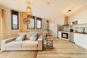 a living room with a couch and a kitchen at Oasis T2 avec terrasse en bord de mer in Saint-Pierre