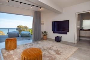 a living room with a tv and a large window at Eagles Nest in Knysna