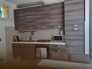 a kitchen with wooden cabinets and a microwave at Residenza Soave in Torrile +5 photos