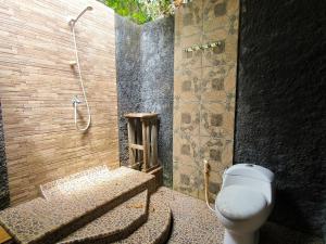a bathroom with a shower with a toilet and a sink at Sunrise Sea Hill Cottages in Karimunjawa