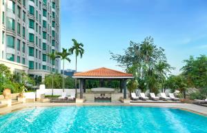 新加坡InterContinental Singapore by IHG的一座游泳池,毗邻一座建筑,设有凉亭