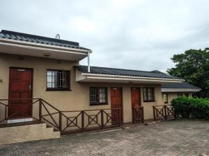 a house with red doors and a porch at Buffalo View Lodge in East London