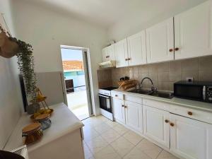 a kitchen with white cabinets and a sink and a stove at Lydias apartment in Panagioúda