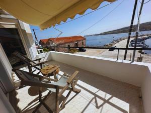a balcony with two chairs and a view of the water at Lydias apartment in Panagioúda