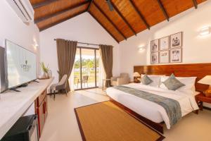 ein Schlafzimmer mit großem Bett und Fernseher in der Unterkunft Uppuveli Beach by DSK in Trincomalee