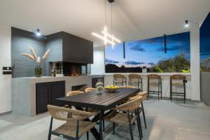 a dining room with a table and chairs in a kitchen at Villa Vatia 2 in Tragaki
