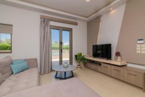 a living room with a couch and a tv at Villa Vatia 2 in Tragaki