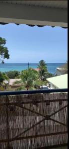a view of the beach from a balcony at L'appartement de la plage in Le Diamant