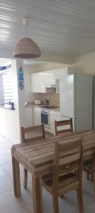 a kitchen with a wooden table and two chairs at L'appartement de la plage in Le Diamant