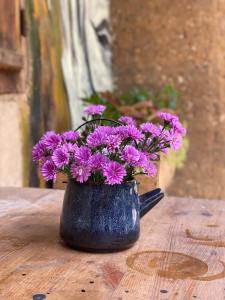 un jarrón negro lleno de flores púrpuras en una mesa en Le Petit Home, en Dồng Văn