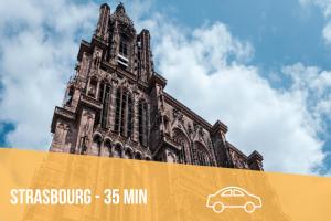a building with a clock tower with a car on it at Mobil home Le Riesling 6 personnes climatisé in Boofzheim