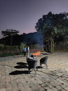two people standing around a fire in a courtyard at The Purple County - Homestay in Lonavala