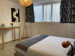 une chambre avec un lit, une table et des fenêtres dans l'établissement Gîte 5 chambres piscine vue montagne, à Ordonnaz 50 autres photos